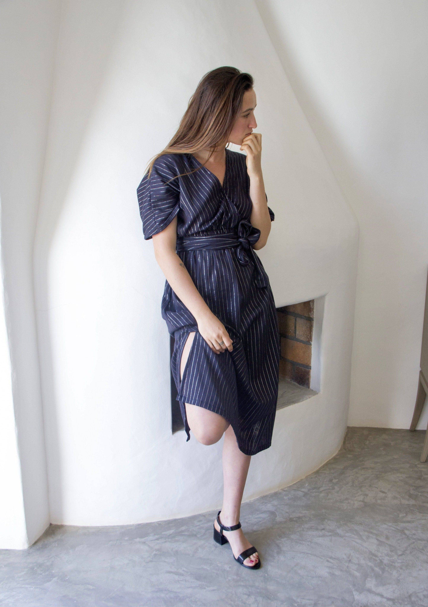 DELPHINE DRESS •  maxi dress gently cinched at the waist for a feminine fit featuring a wrap-around belt, open low v-neckline with wide short sleeves, and side slits in the skirt in a silver fleck pinstripe fabric. Available in one size.